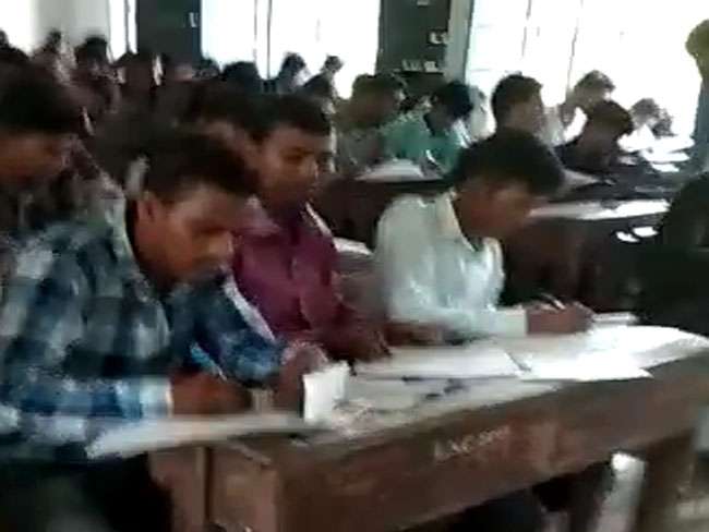 बिहार में गिरती शिक्षा व्यवस्था का एक और नमूना मुजफ्फरपुर के एलएस कॉलेज में देखने को मिला है। जहां कॉलेज में बीए के द्वितीय वर्ष की प्रैक्टिकल परीक्षा के दौरान छात्रों ने जमकर नकल की जिसका वीडियो वायरल हो रहा है तो वहीं, कॉलेज प्रशासन इससे अनजान बना रहा।  वीडियो में दिख रहा है कि कैसे मुजफ्फरपुर के एलएस कॉलेज में बीए द्वितीय वर्ष की परीक्षा चल रही है और इस दौरान छात्र खुलेआम टेबल पर किताब रखकर मोबाइल और किताबों से नकल करते नजर आ रहे हैं। अगर इससे भी बात नहीं बन रही है तो अपने अगल-बगल के छात्रों के पास बैठकर उनकी किताबों और कॉपियों से नकल कर रहे हैं। और शिक्षक इन सबसे अनजान बने हुए हैं।  वायरल वीडियो में छात्रों को नकल करते साफ-साफ देखा जा सकता है। वहीं, दूसरी ओर जिला प्रशासन पूरे मामले पर कुछ भी बोलने को तैयार नहीं है।    प्रशासनिक पदाधिकारी या शिक्षा विभाग के लोग भी इसपर चुप्पी साधे हुए हैं। बिहार की शिक्षा व्यवस्था पर लगातार सवाल उठते रहे हैं। चाहे मैट्रिक के परीक्षा में छात्रों के पेपर चोरी का मामला हो या इंटर परीक्षा में गड़बड़ी का और इस वीडियो के सामने आने के बाद एक बार फिर गुणवत्ता पूर्ण शिक्षा पर सवाल खड़े हो गए हैं। 